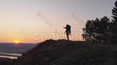 日落时分，父亲和他的小<strong>婴儿</strong>在山上小径上徒步旅行的<strong>剪影</strong>。
